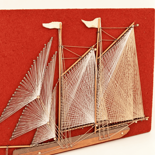 Angled view of string art sailboat with white and gold thread sails, photo 2 of 5