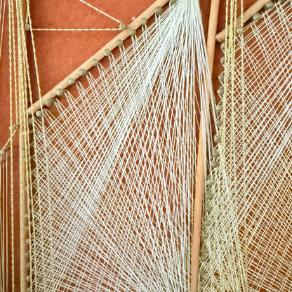Detail of crisscrossed white and gold thread on string art sail, photo 4 of 5