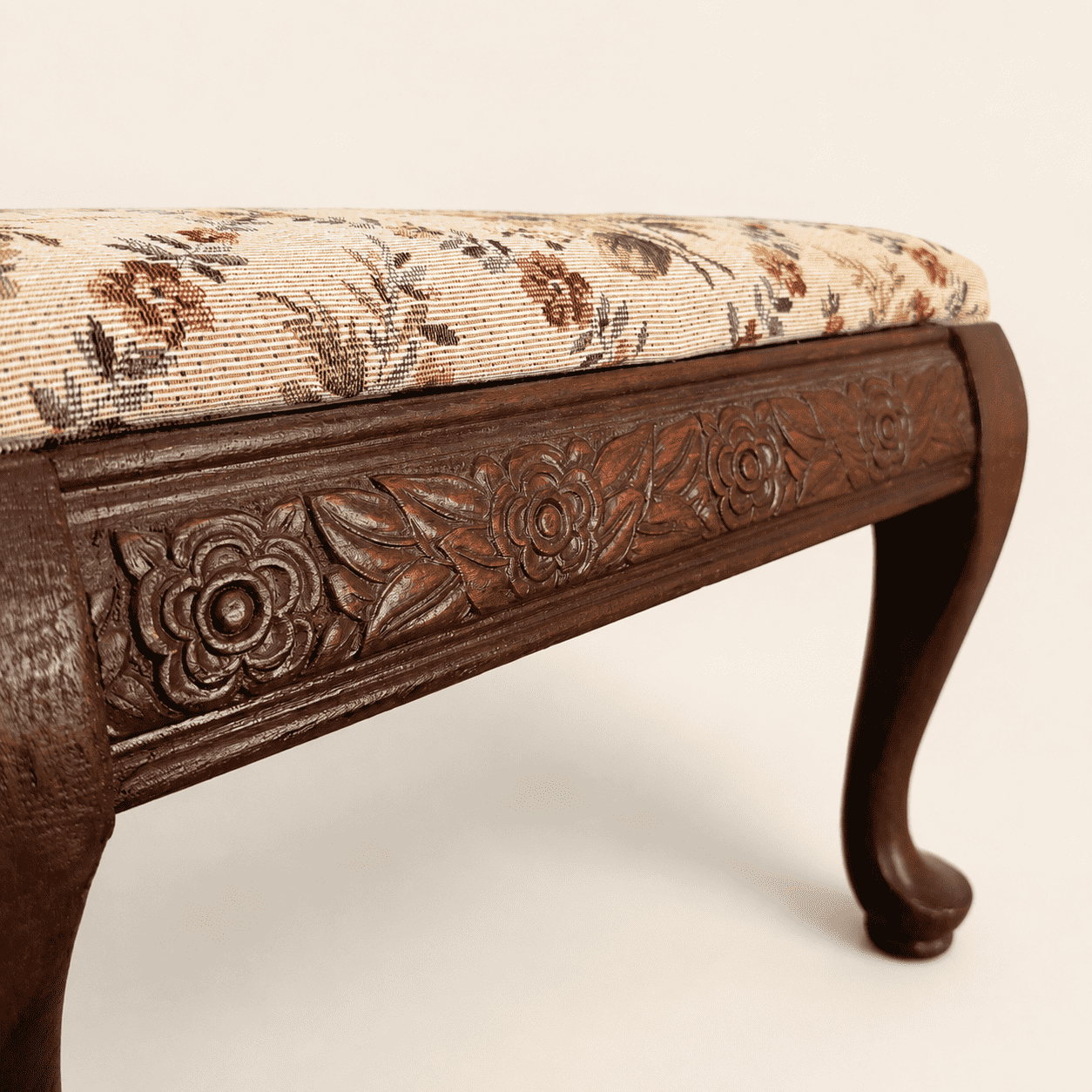 Detail of the carved rose-and-foliage apron on the footstool