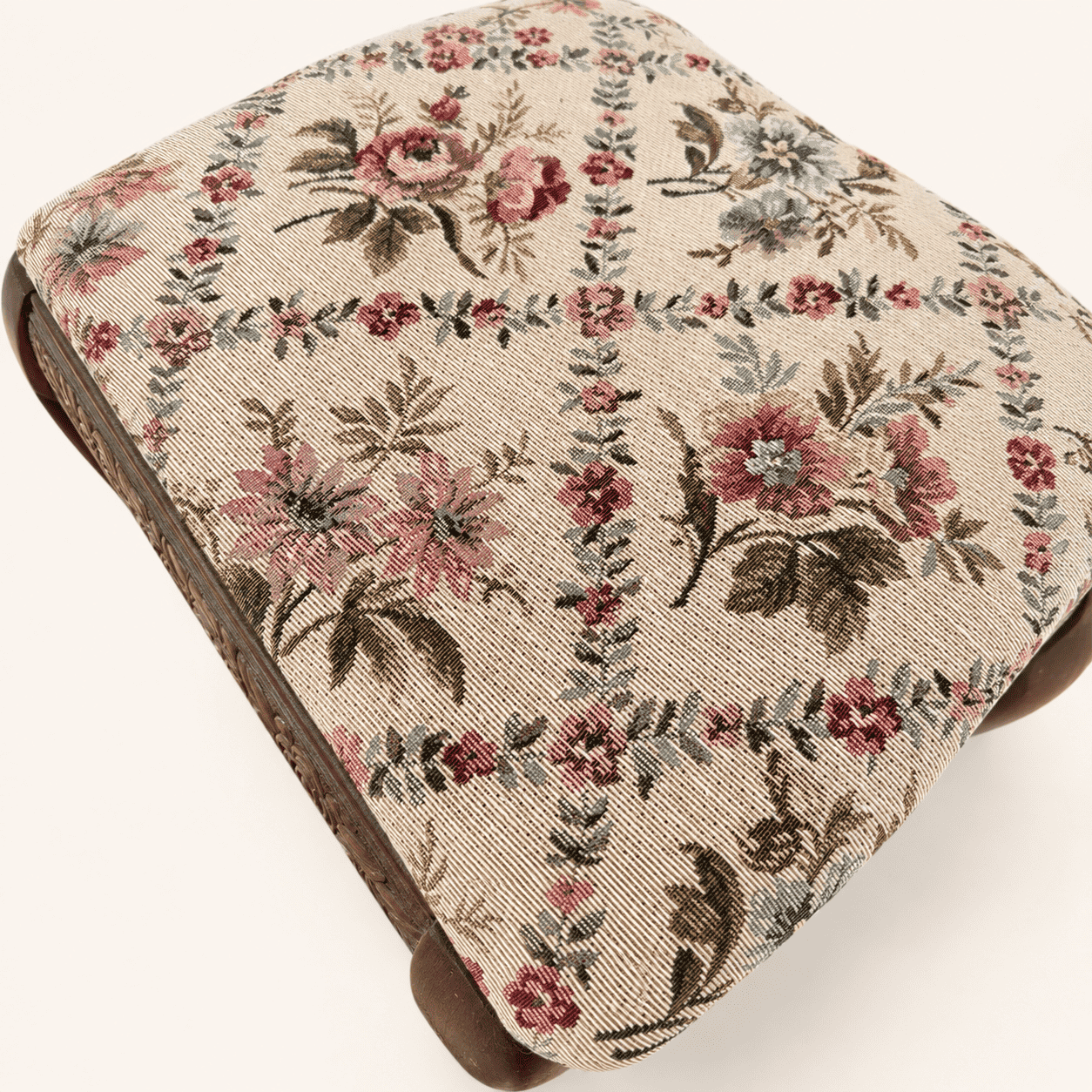 Detail of the rose-and-blossom tapestry pattern on the footstool top