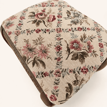 Detail of the rose-and-blossom tapestry pattern on the footstool top
