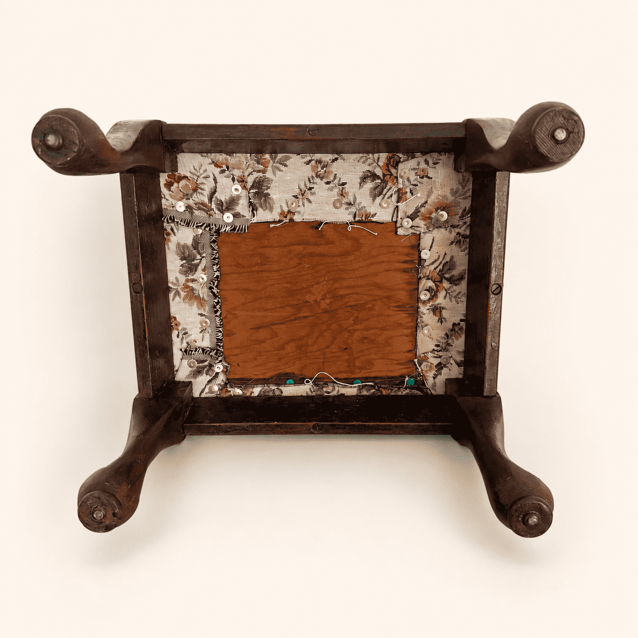 Underside of the footstool showing frame and tapestry-covered base