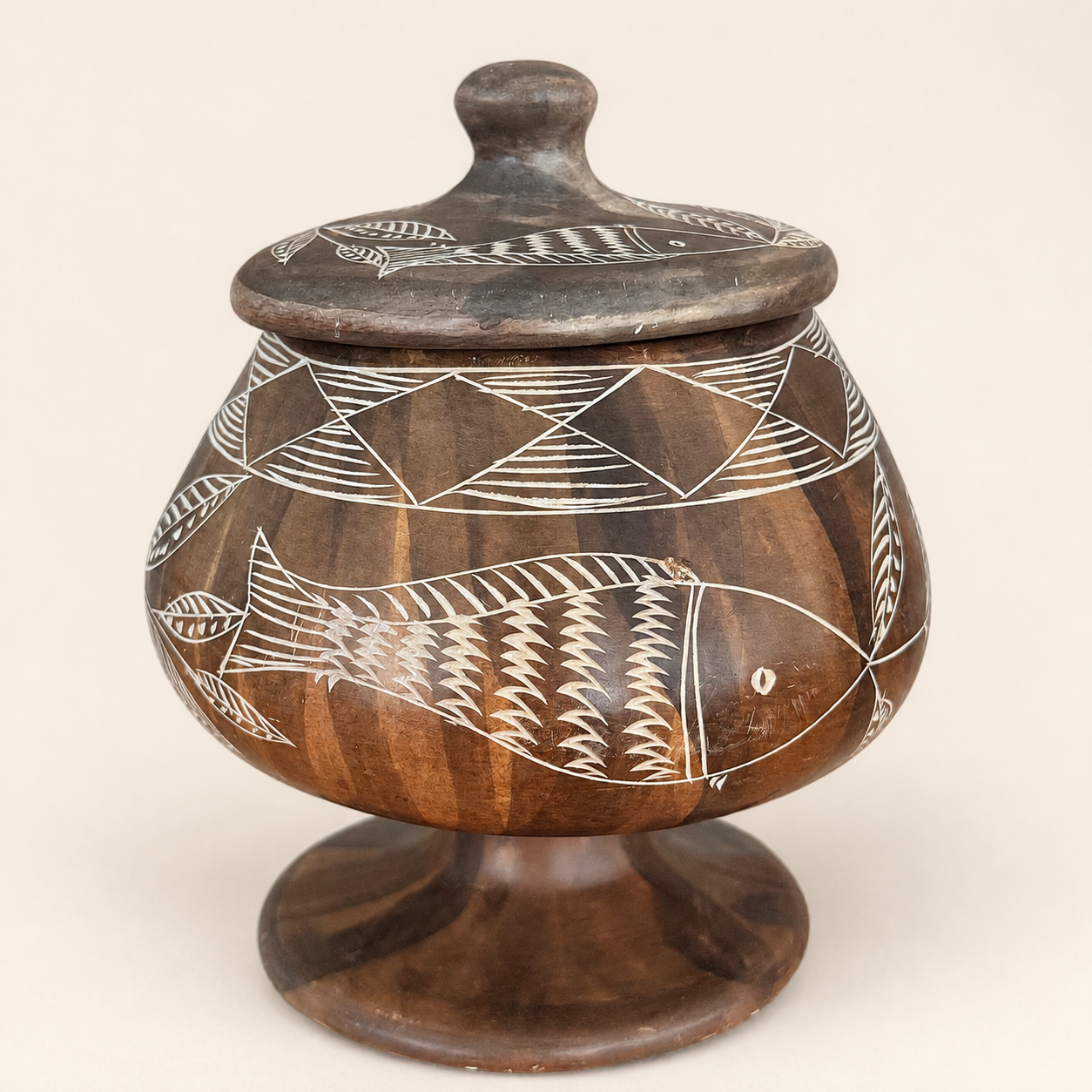 Angled view of carved soapstone lidded jar with white etched pattern
