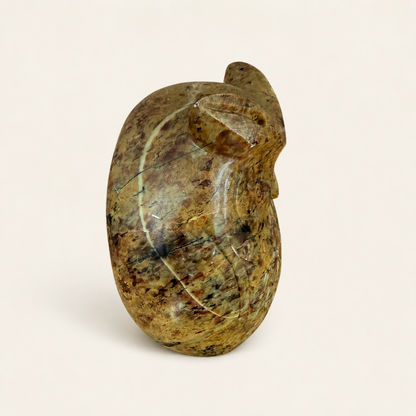 Angled view of carved stone owl figurine showing feather detail