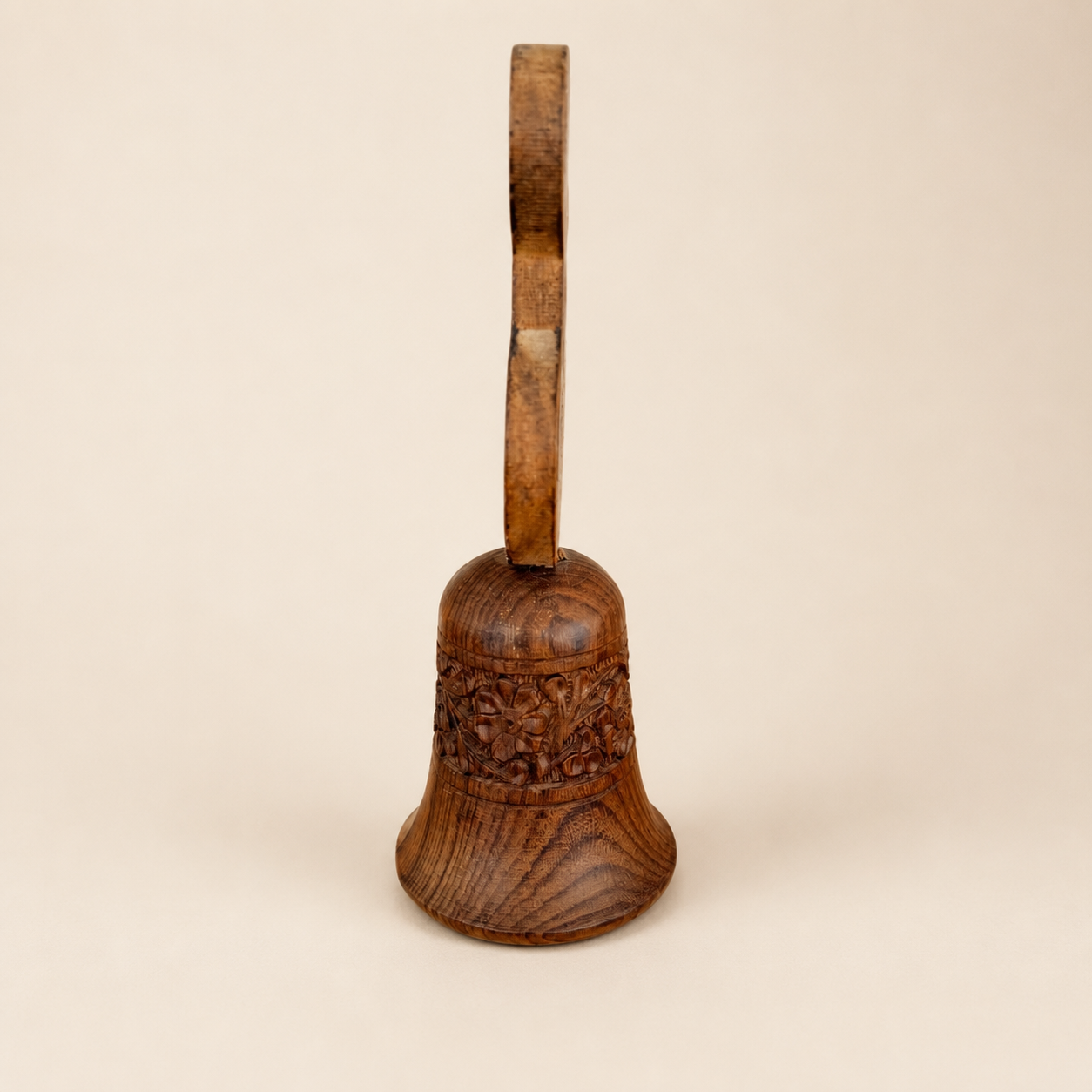 Side view of wooden hand bell showing treble clef handle