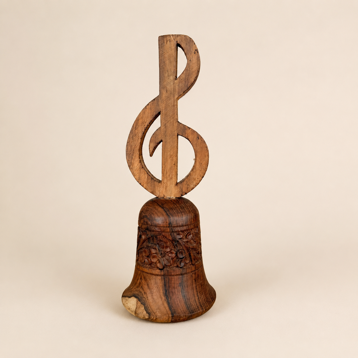 Vintage carved wood hand bell with treble clef handle and floral band, front view