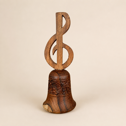 Vintage carved wood hand bell with treble clef handle and floral band, front view