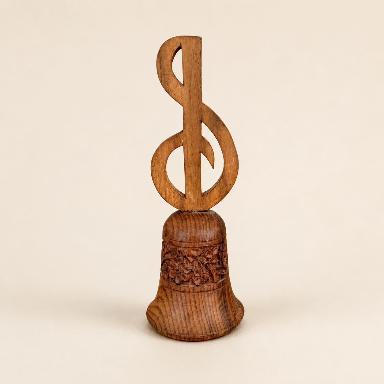 Angled view of carved wood hand bell with treble clef handle