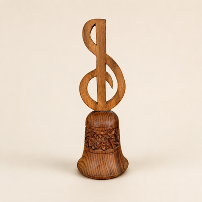 Angled view of carved wood hand bell with treble clef handle
