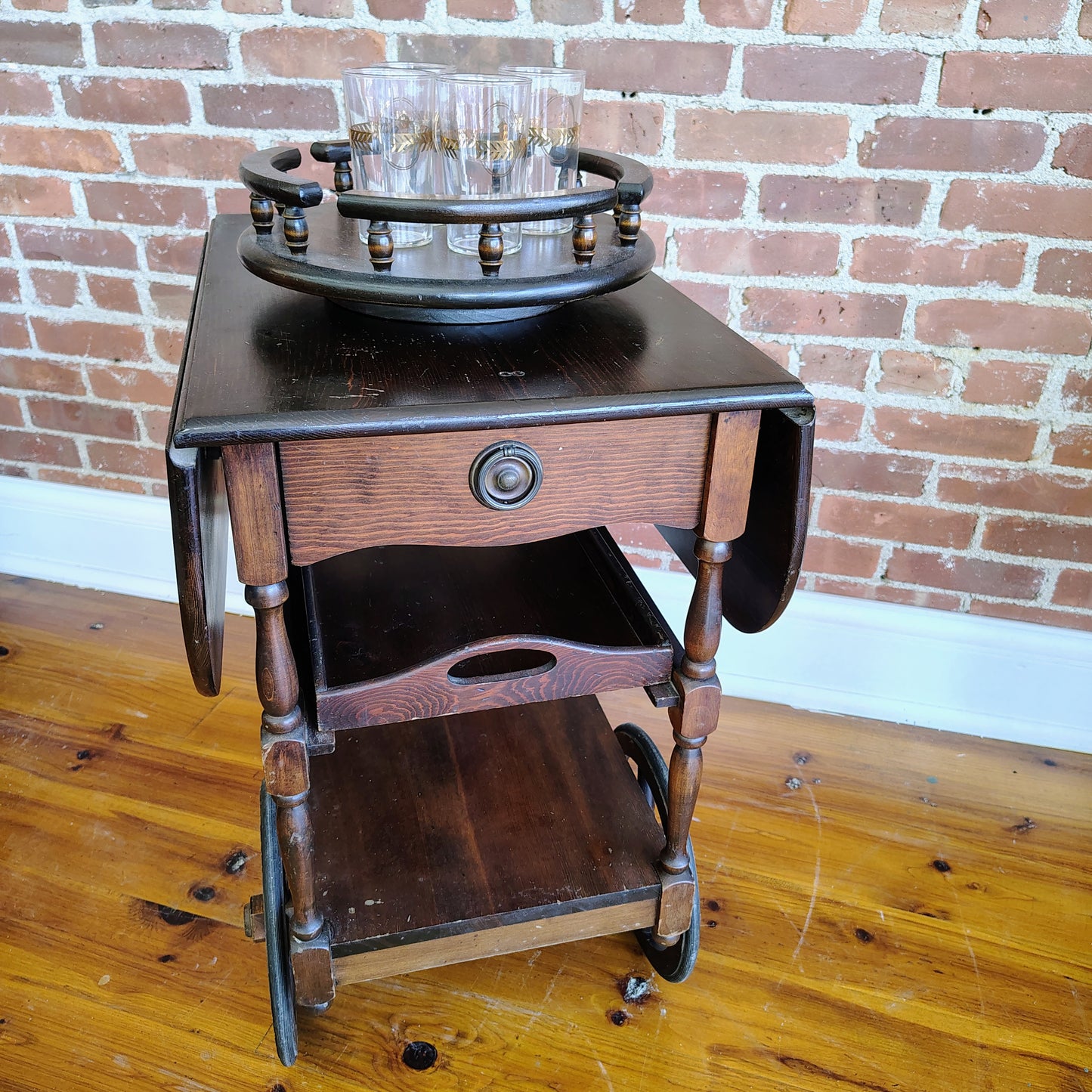 Vintage dark wood tea cart with drawer and removable tray on whee