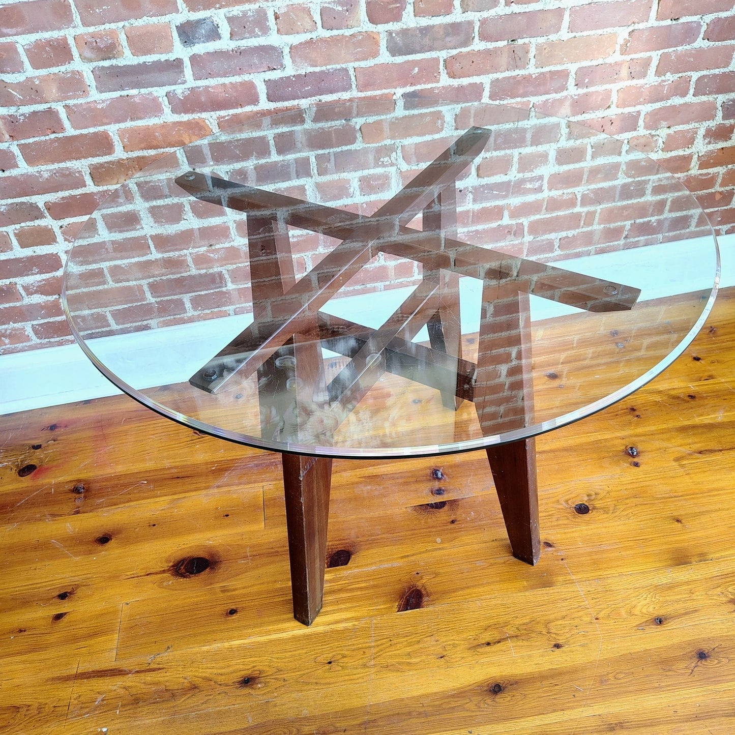 Full view of vintage Ethan Allen round glass dining table with tapered wood legs