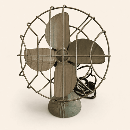 Vintage Faultless sage green metal electric desk fan, three-quarter angle view