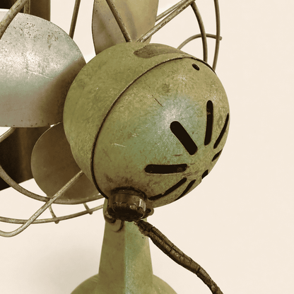 Close-up of the four steel blades and wire cage on the vintage Faultless fan
