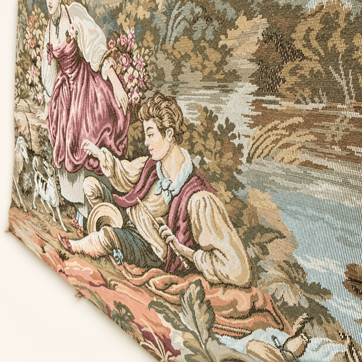 Close up of the young man playing a flute by the river on a vintage pastoral tapestry