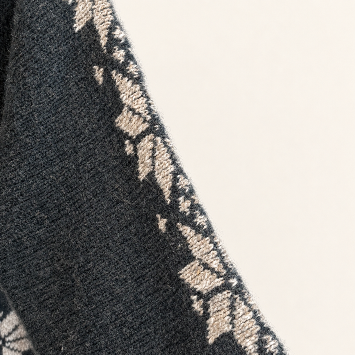 Nordic snowflake motif down the sleeve of a green wool sweater