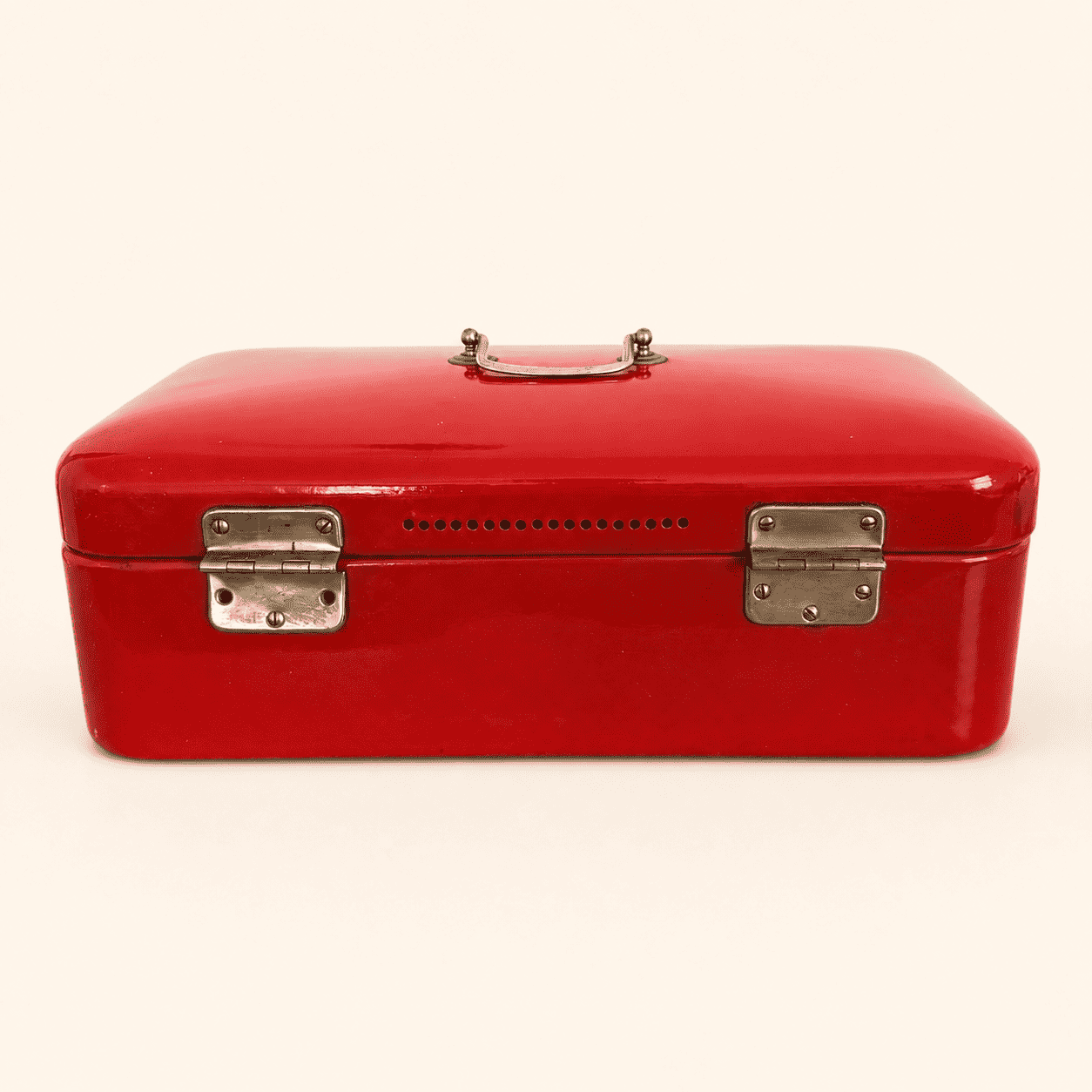 Back of the red enamel bread box showing ventilation holes and hinges