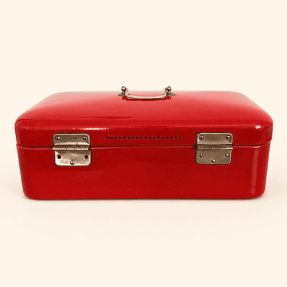 Back of the red enamel bread box showing ventilation holes and hinges