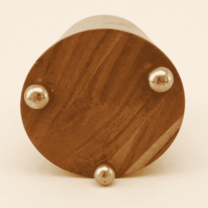 Base of walnut wine chiller showing three polished brass ball feet