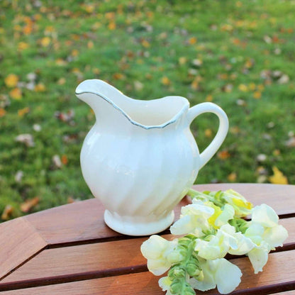 Vintage white ceramic swirl creamer with silver trim, photo 1 of 10