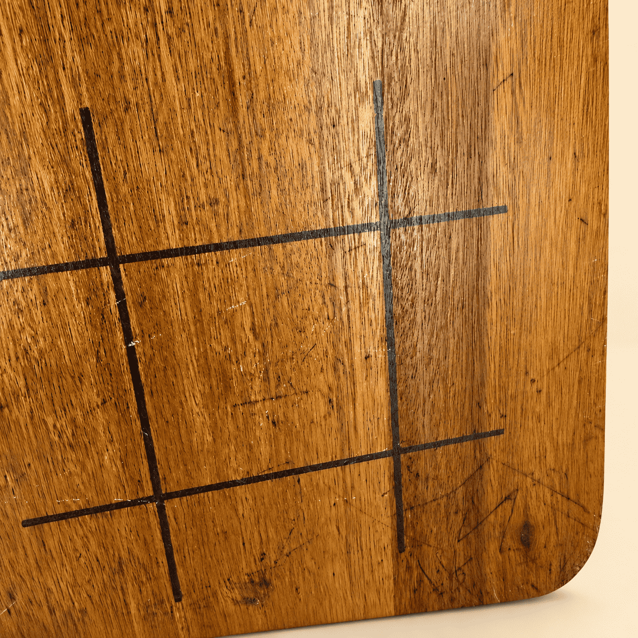 Detail of the hand-drawn tic-tac-toe lines on the wood board