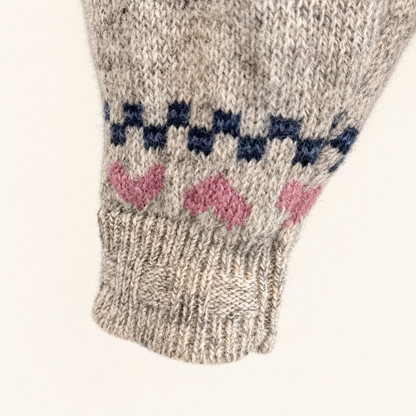 Hem of Woolrich folk sweater with pink hearts and navy zigzag