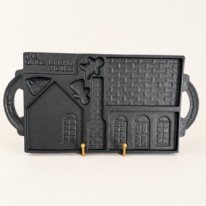 Angled view of the cast iron gingerbread house mold on a stand